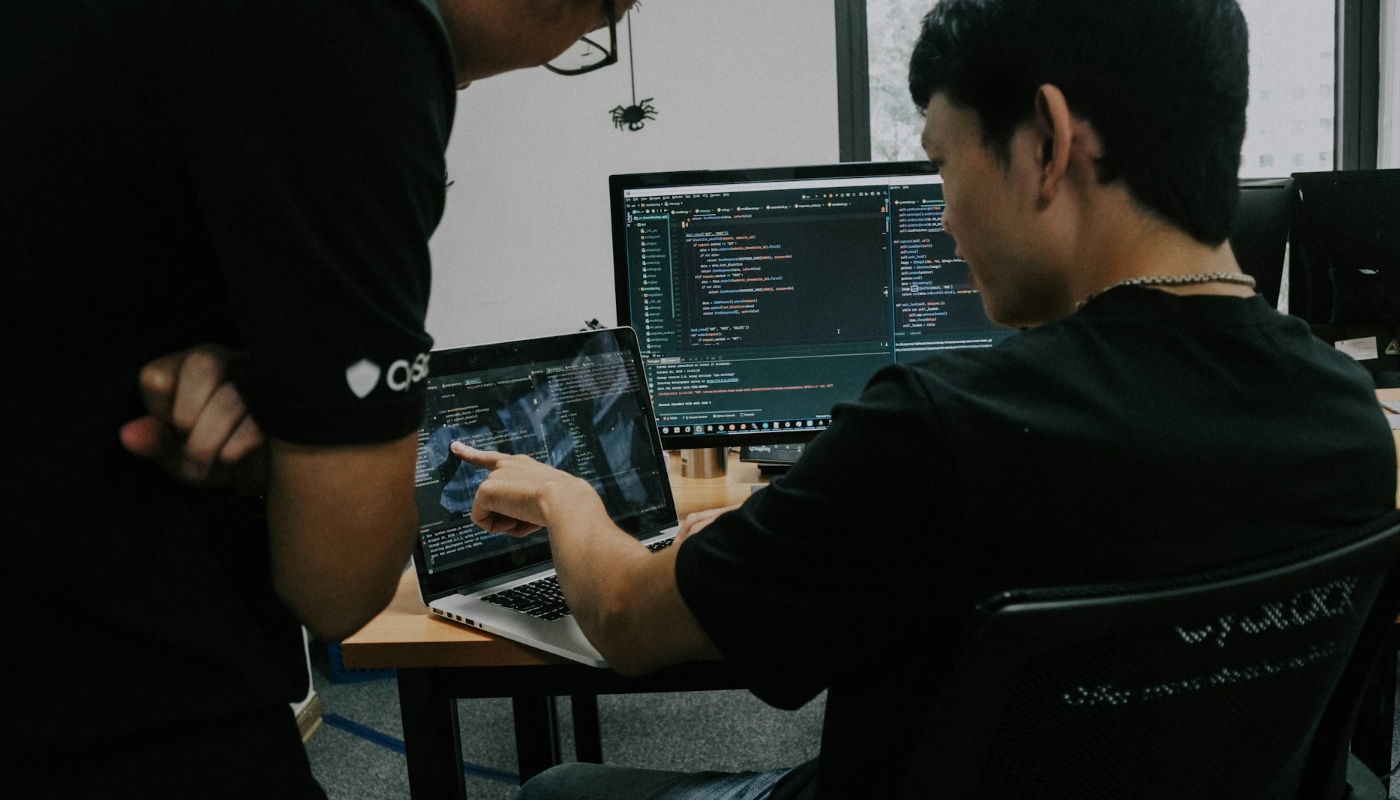 Cyber Security Technologist header image of two men looking at code on two computer screens
