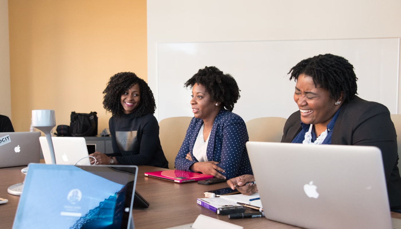 Apprenticeship Funding header image of three women sitting at a boardroom table with laptops, smiling