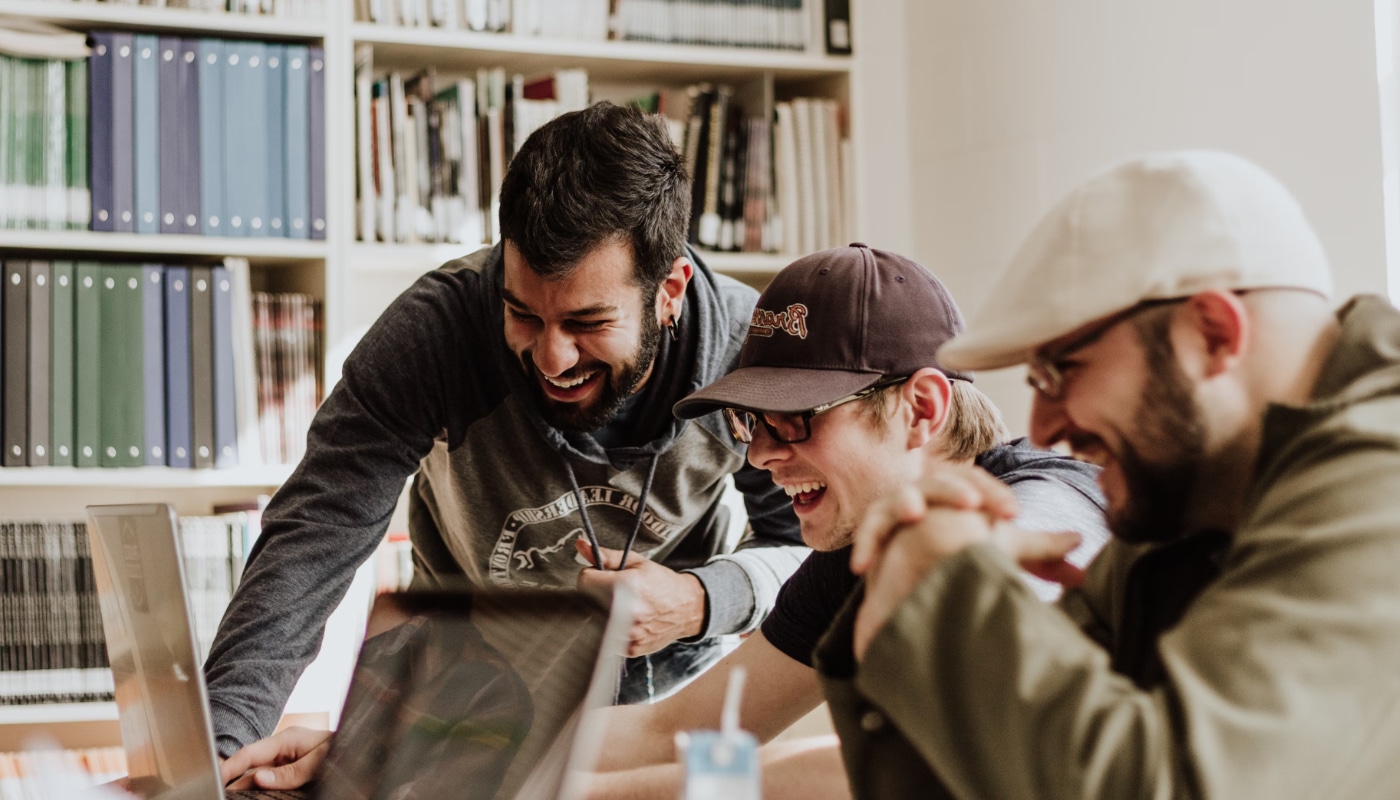 Students header image of three young men laughing at a laptop screen